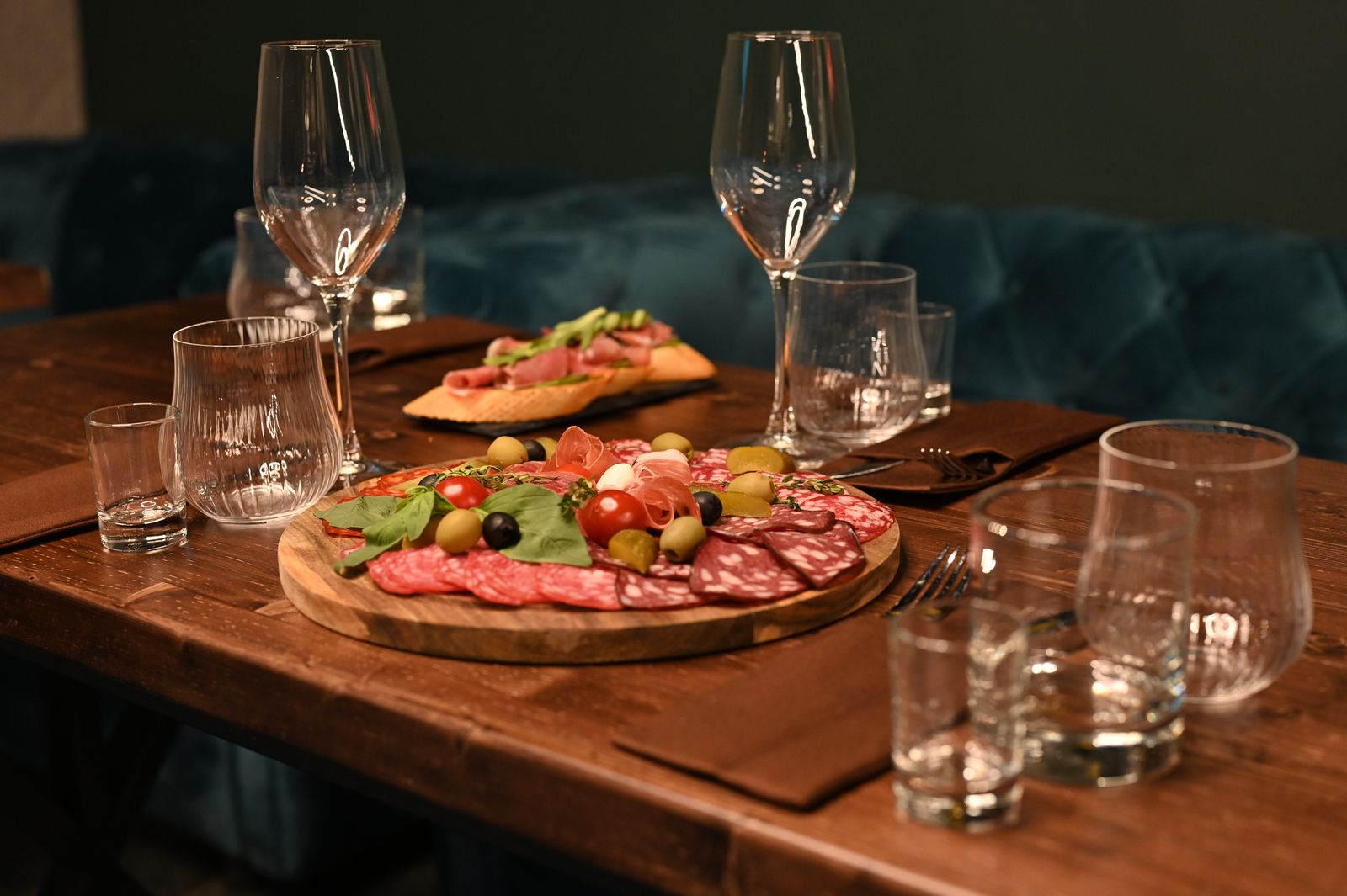 Charcuterie board and glassware set on a warmly lit table